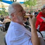 Spike enjoying one of the huge
pretzel sticks that R. B. bought
at Happy Hour to share with the rest of the Geezers. 
You can see R. B, with the red
shirt, and golf hat also chomping down on one.