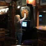 Here is bartender Karen and 
her second love the Dart Machine. During her breaks she likes to challenge customers such as Geezer
Drumstir.