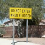 A SIGN IN SUNFLOWER ESTATES WARNING OF THE POSSIBILITY OF FLOODING DOWN THE ROAD IN THE NEXT PICTURE!  