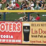 A sign in on the otufield home run fence adveritsing a familiar restaurant which I never had a chance to visit.  